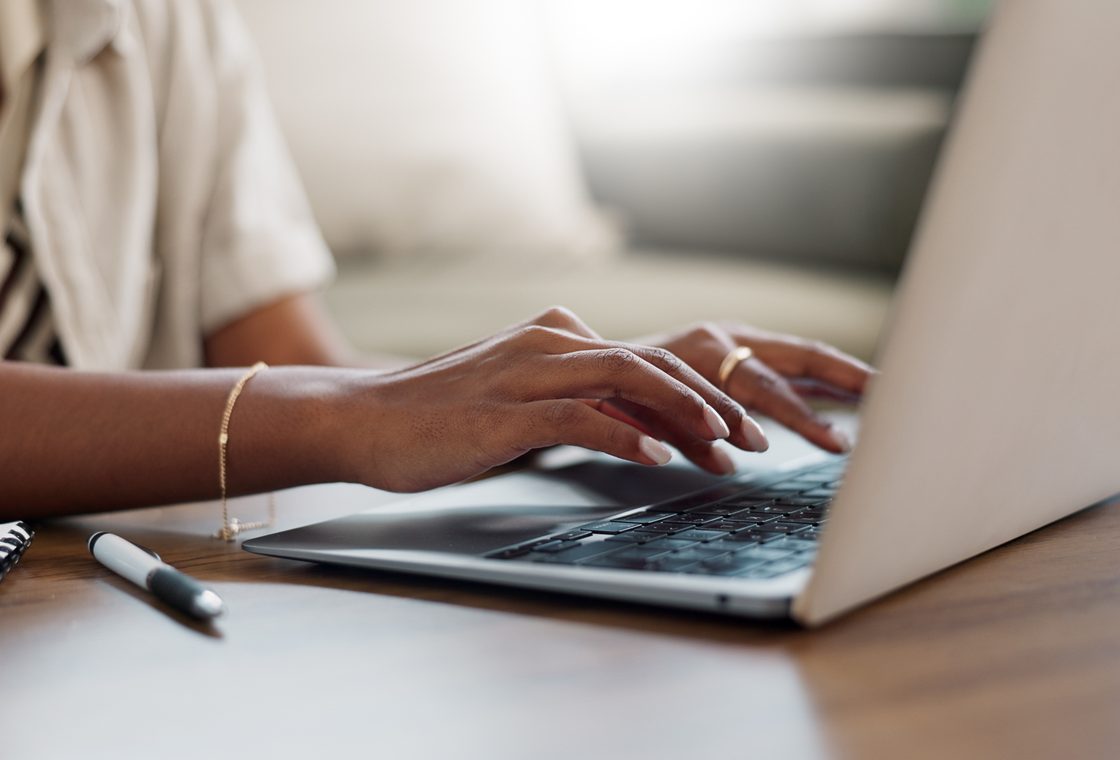 A person using a laptop at a desk.