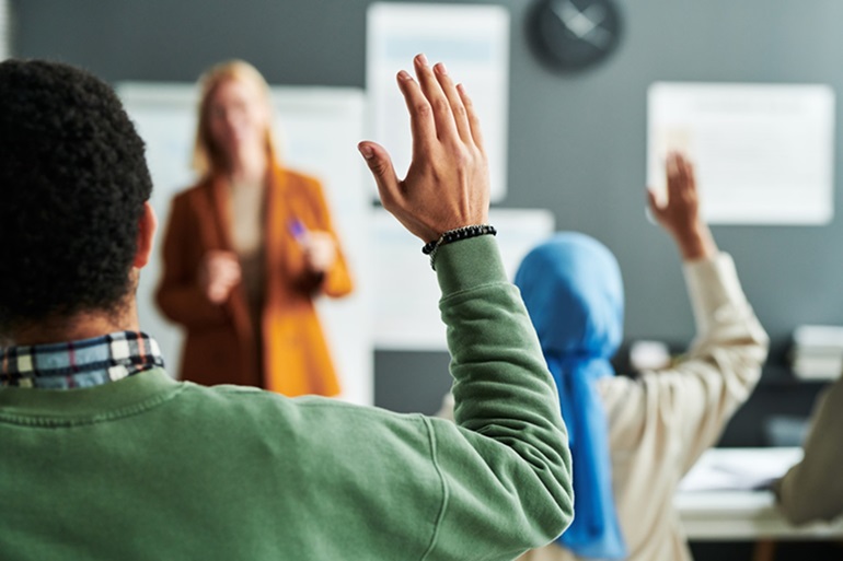 People raising their hands in a class or workshop.